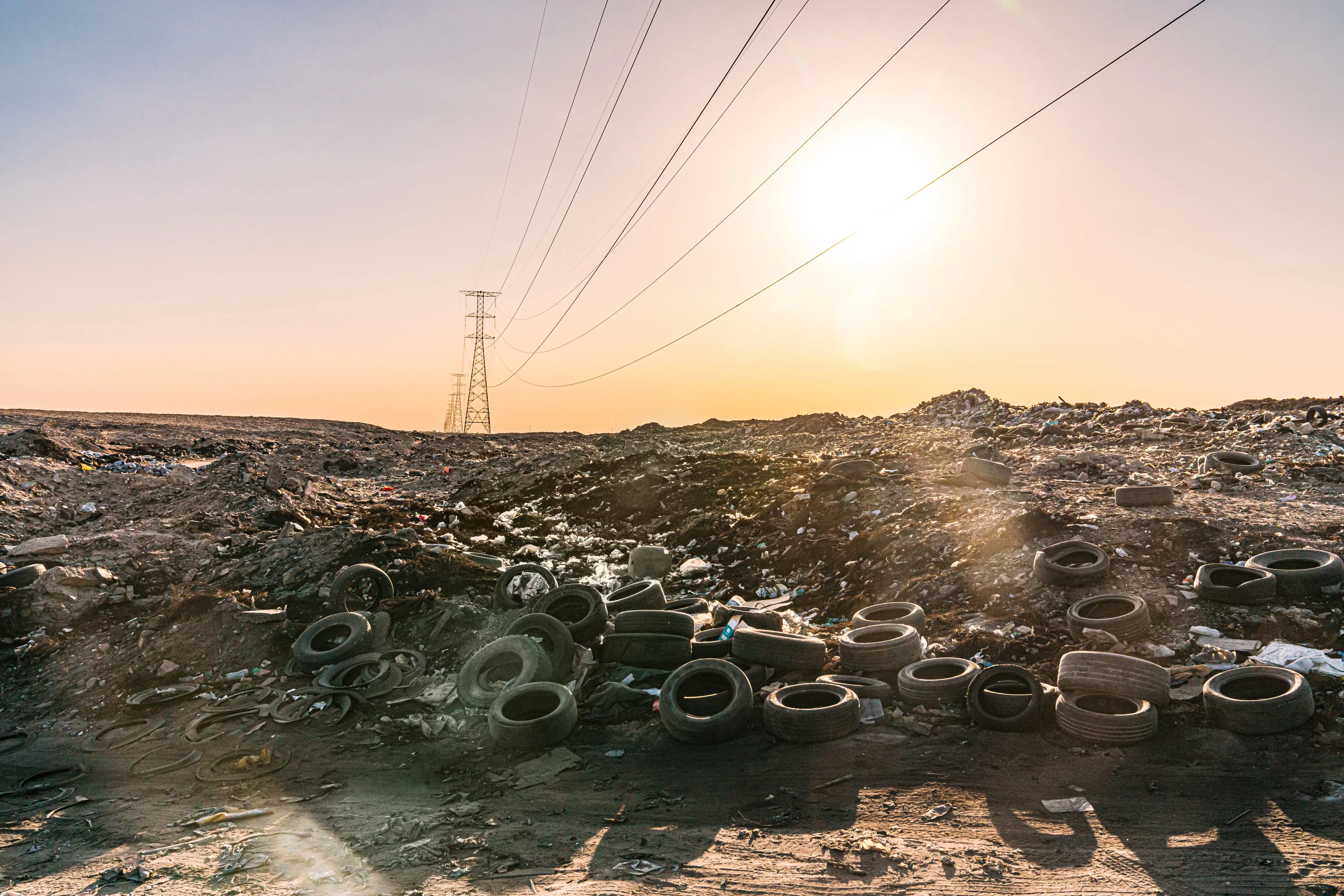 Municipal solid waste landfill with discarded tires and power lines highlighting waste-to-energy and MSW management potential